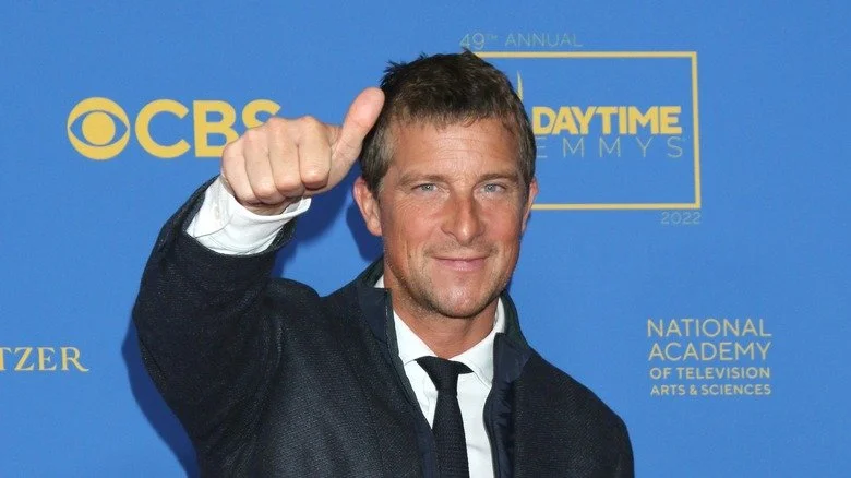 Bear Grylls en costume faisant un signe de pouce