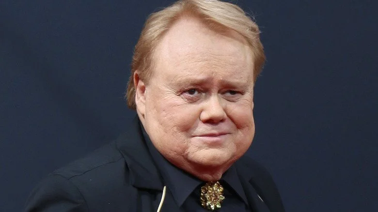 Louie Anderson souriant avec une broche