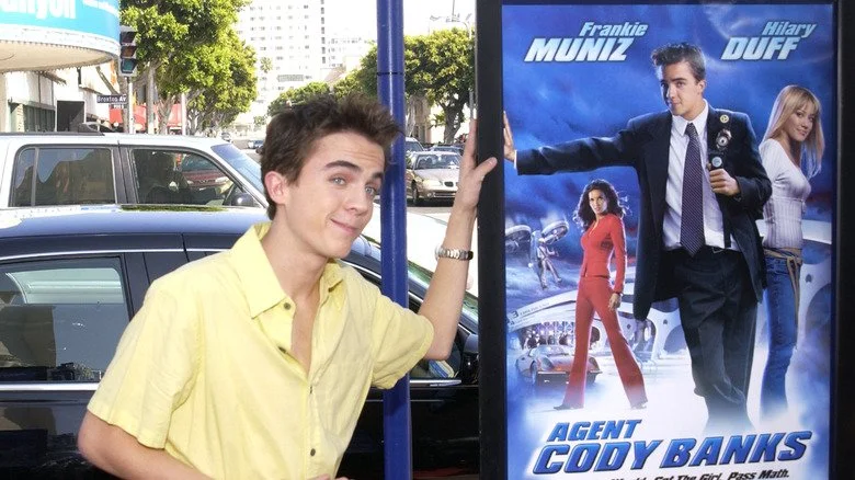 Frankie Muniz posant avec l'affiche du film Agent Cody Banks