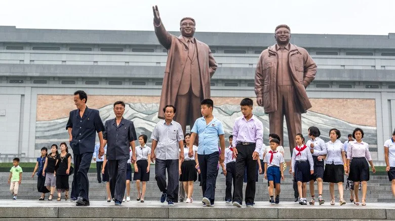 Citoyens nord-coréens devant la statue de Kim Jong