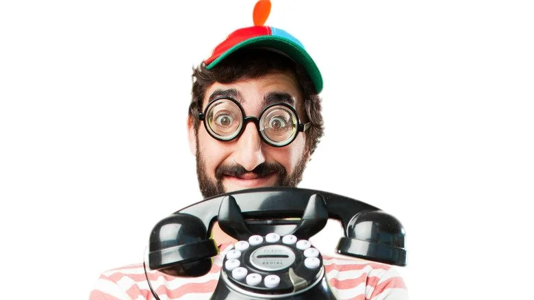 Personne tenant un ancien téléphone pour le poisson d'avril