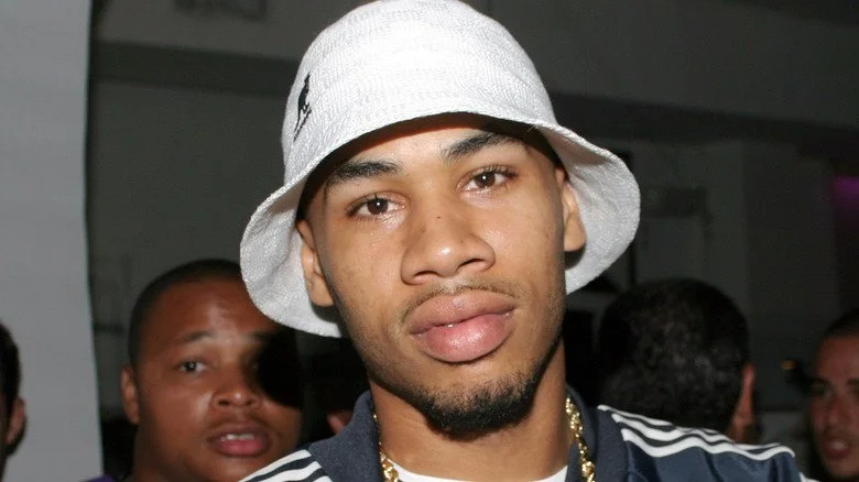 R Prophet portant un chapeau Kangol et un survêtement Adidas