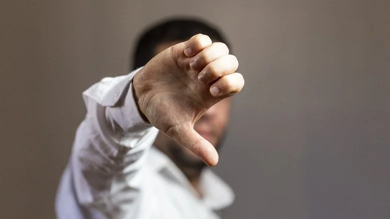 Un homme montrant un pouce vers le bas
