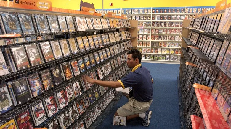 employé remplissant des étagères Blockbuster