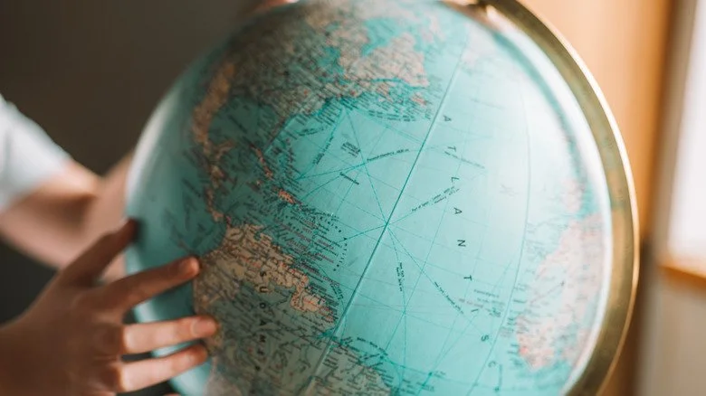 Un globe avec la main de quelqu'un dessus