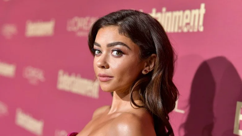 Sarah Hyland sur le tapis rouge avec un fond rose