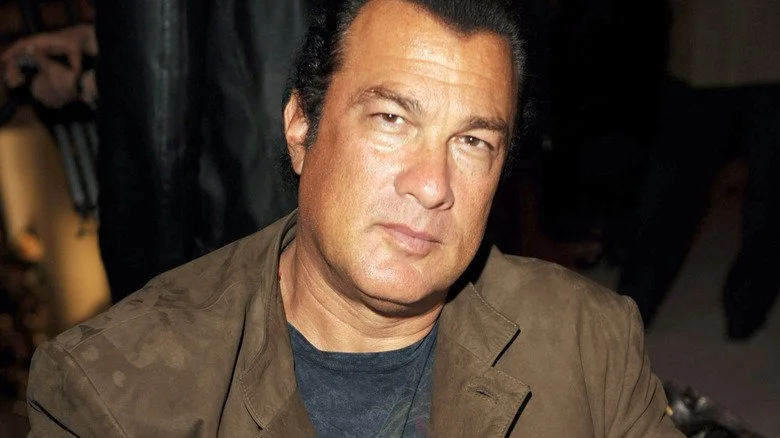 Steven Seagal dans une chemise noire et une veste beige
