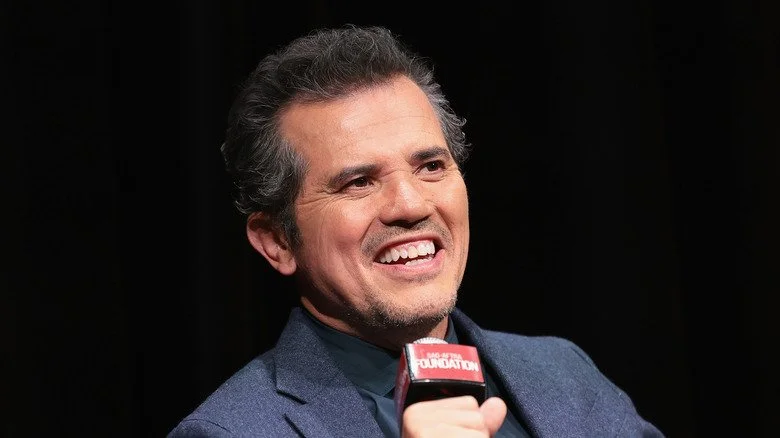 John Leguizamo souriant en parlant dans un microphone