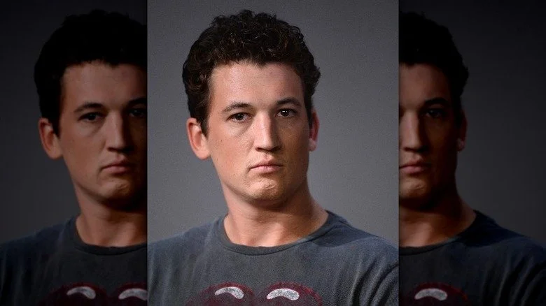 Miles Teller portant une chemise grise et avec une expression sérieuse