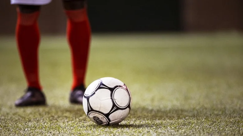 Joueur de football à côté d'un ballon