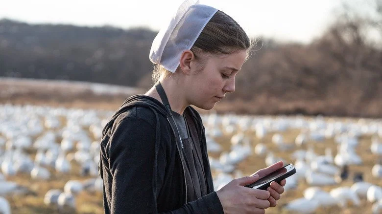 Jeune fille amish vérifiant son téléphone