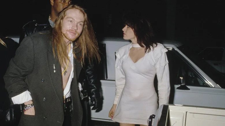 Axl Rose et Erin Everly habillés devant une voiture