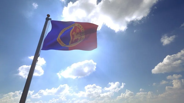 Drapeau de la nation comanche flottant contre un ciel bleu