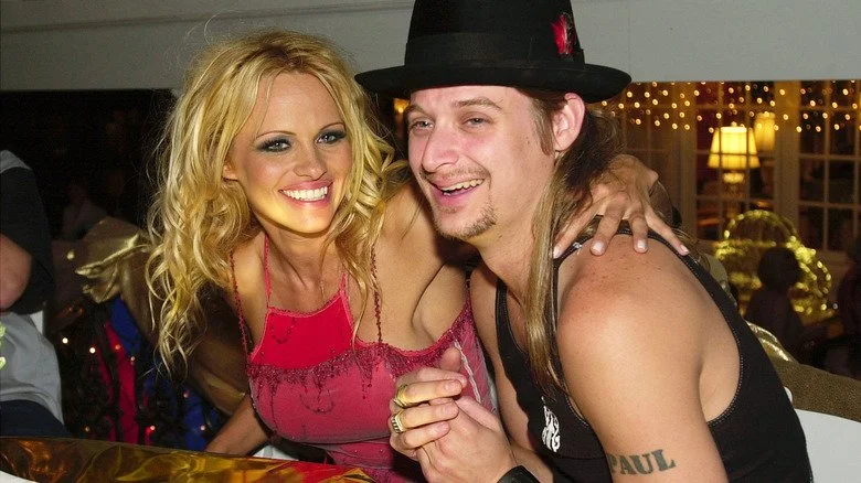 Kid Rock et Pamela Anderson souriant à une table lors d'un événement