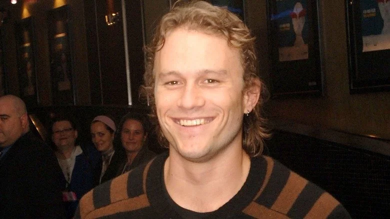 Heath Ledger souriant avec un pull rayé