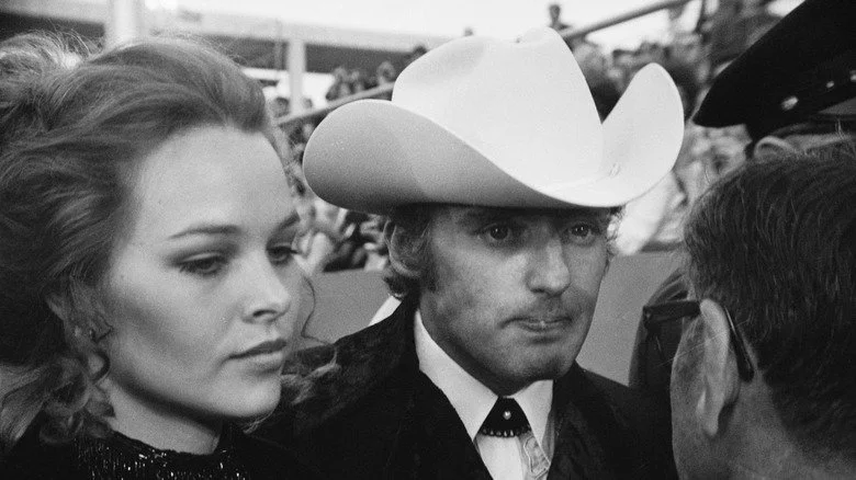 Michelle Phillips et Dennis Hopper parlant à un journaliste sur un tapis rouge