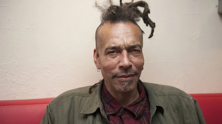 Chuck Mosley assis sur un canapé et posant pour une photo en 2016