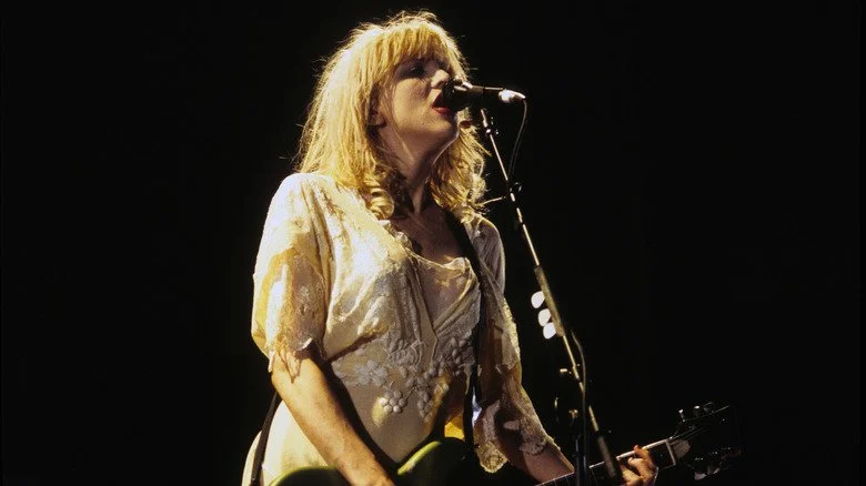 Courtney Love chantant et jouant de la guitare sur scène au Roy Wilkins Auditorium en 1994