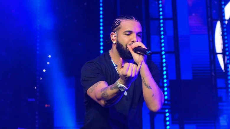 Drake en tenue sombre sur scène avec un microphone