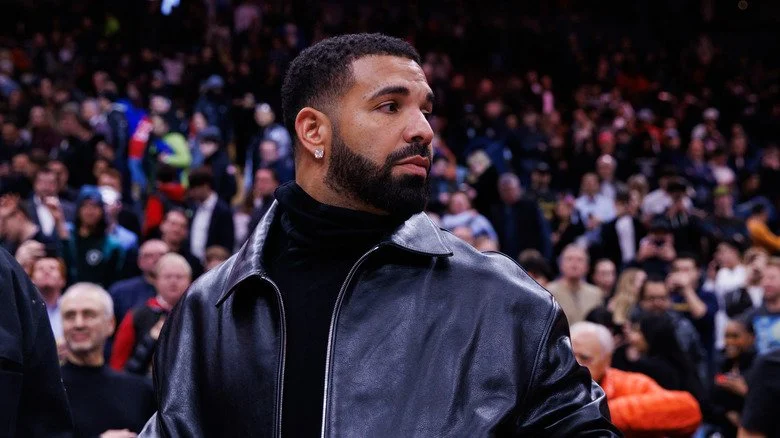 Drake en veste sombre lors d'un match de basket