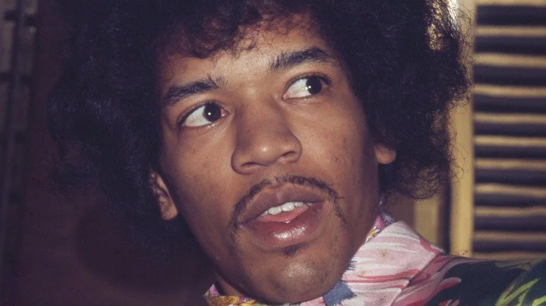 Jimi Hendrix regardant sur sa gauche dans une chemise à fleurs