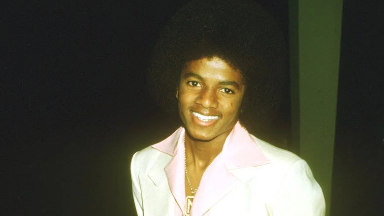 Jeune Michael Jackson souriant en costume blanc