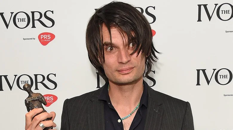 Jonny Greenwood de Radiohead tenant un prix avec des yeux fous
