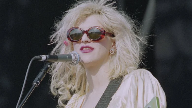 Courtney Love portant des lunettes de soleil et chantant sur scène au Reading Festival 1994