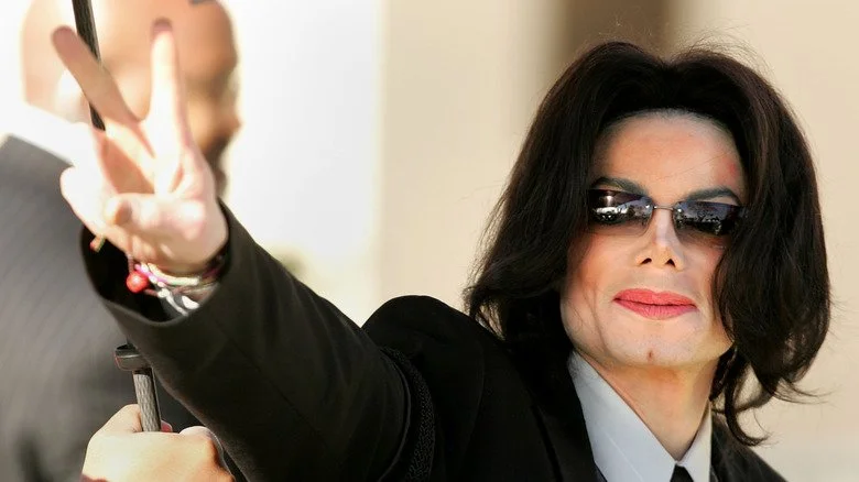 Michael Jackson en lunettes de soleil faisant un signe de paix