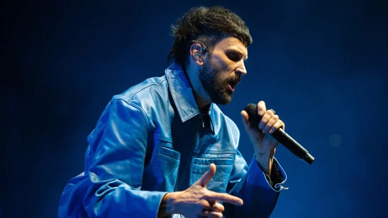 Serge Pizzorno de Kasabian chantant sur scène au O2 Arena en 2024
