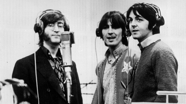 Lennon, Harrison et McCartney chantant derrière un micro