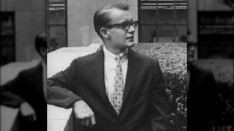 Michael Rockefeller s'appuyant sur une barrière