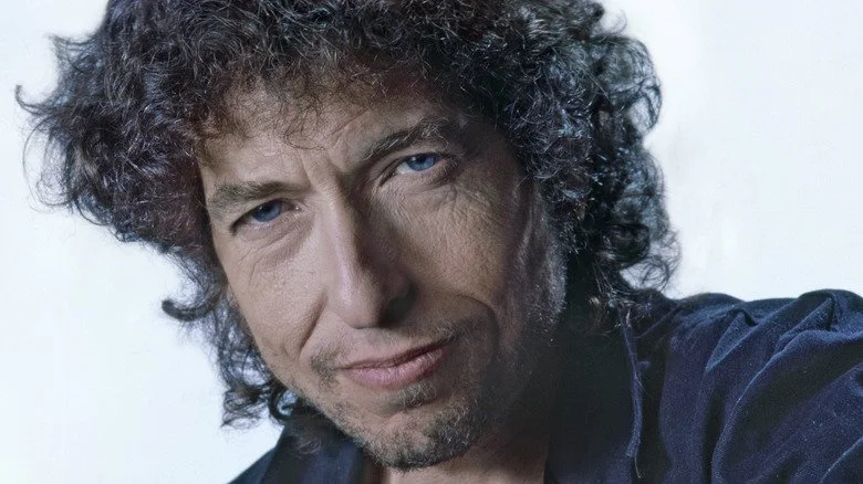 Bob Dylan souriant en chemise bleue, portrait de 1986