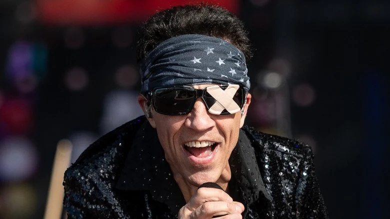 Gary Cherone en performance avec Extreme en 2024 avec un bandana et des lunettes de soleil