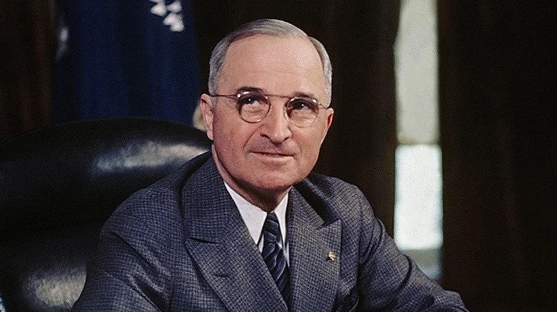 Harry Truman assis à son bureau présidentiel