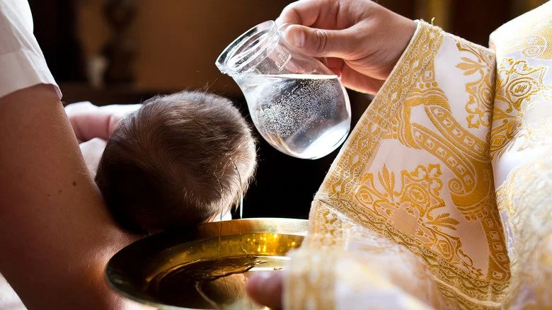 Un prêtre catholique baptisant un nourrisson