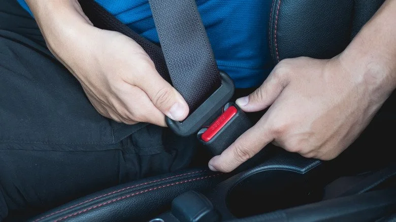 Homme attachant sa ceinture de sécurité