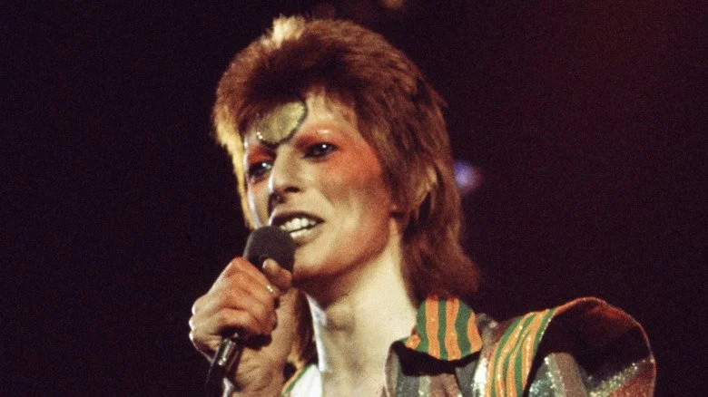 David Bowie chantant sur scène dans le personnage d'Aladdin Sane