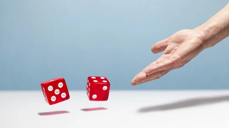 Main lançant deux dés