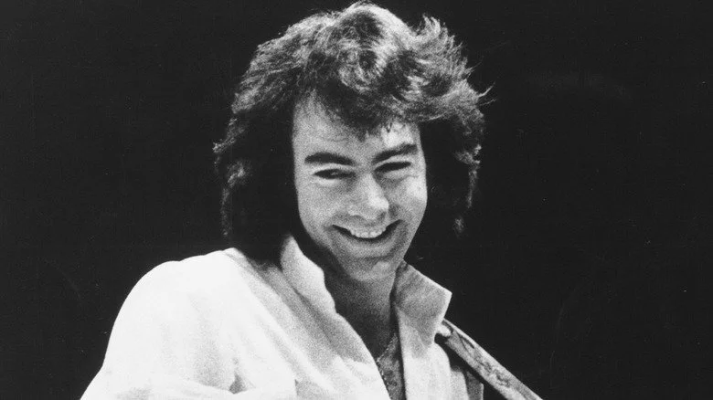 Neil Diamond avec des cheveux longs et une chemise ouverte
