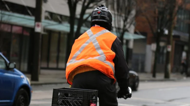 Homme en gilet réfléchissant fait du vélo