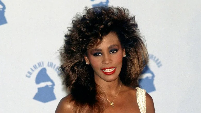 Whitney Houston avec une coiffure volumineuse lors d'une cérémonie des Grammy dans les années 1980