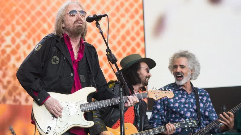 Tom Petty, Mike Campbell, et Ron Blair en performance sur scène ensemble