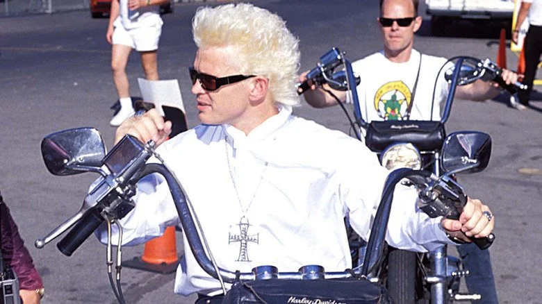 Billy Idol portant des lunettes de soleil et roulant en moto