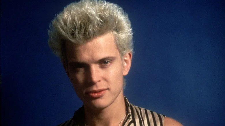 Billy Idol regardant la caméra en portant un gilet rayé