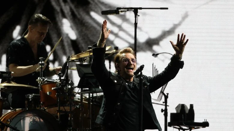 Bono sur scène levant les mains