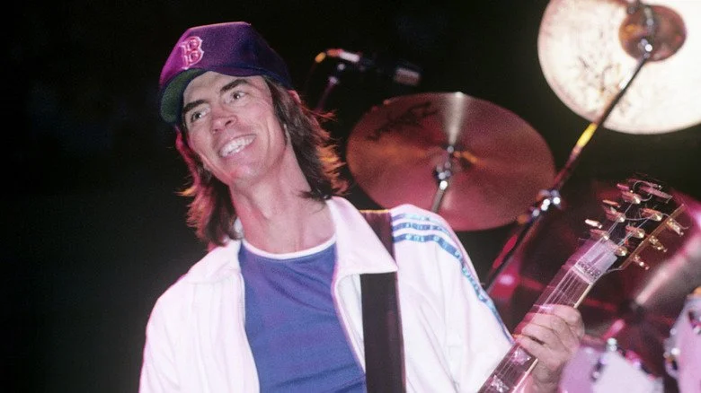 Tom Scholz souriant sur scène en 1987