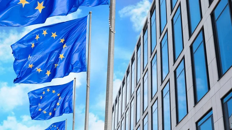 Drapeaux de l'Union Européenne devant un bloc de bureaux
