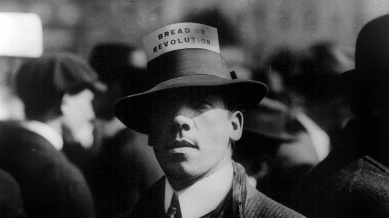 Homme avec un chapeau IWW disant Pain ou Révolution