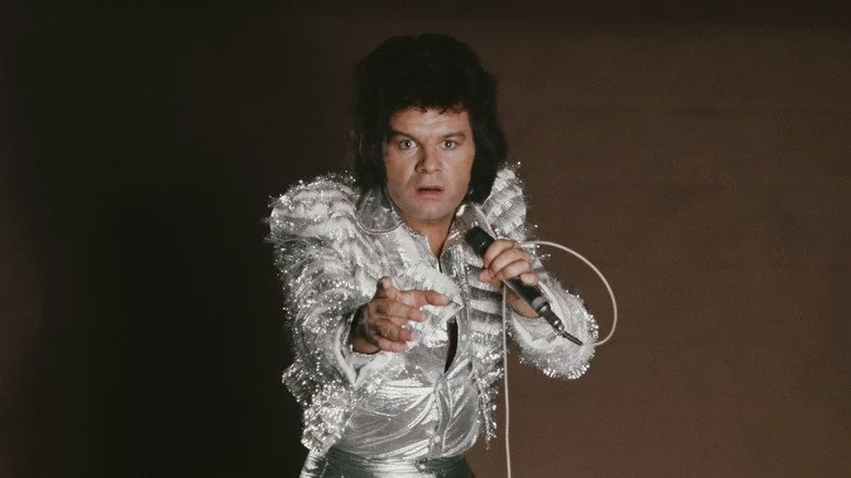 Gary Glitter posant avec un microphone